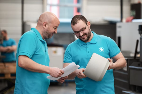 Sager und Mack Impressionen Freude am Arbeitsplatz zwei Herren blaue Arbeitskleidung in Besprechung