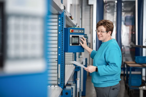 Sager und Mack Personen Freude am Arbeitsplatz Lager Frau in blauem Pullover bedient Terminal